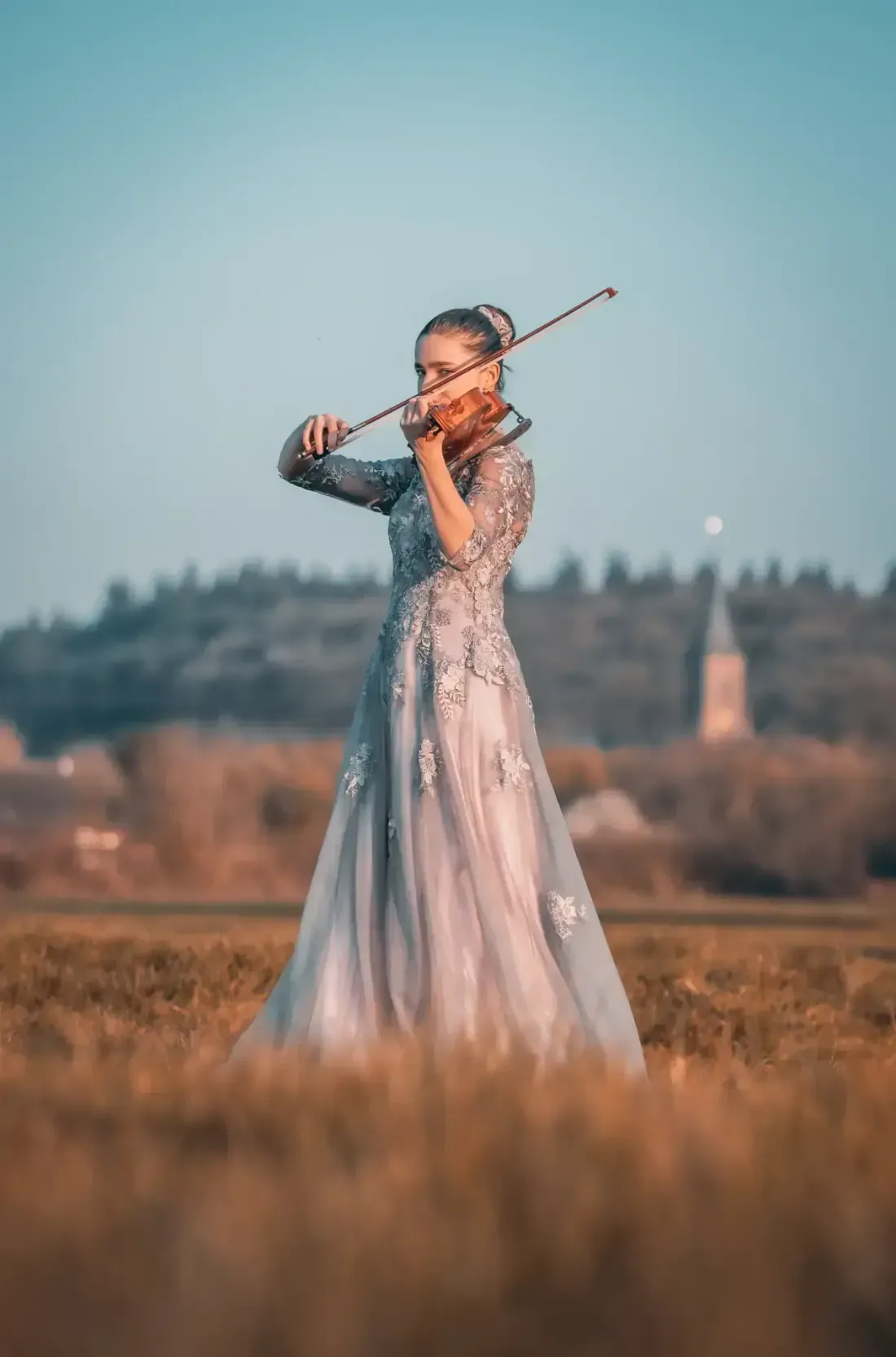 Violinistin in einem Kleid spielt im Freien